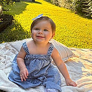 Ellie joined the competition — help win amazing prizes! baby, blanket, bow, child, cute, daylight, dress, footwear, grass, greenery, happy, infant, nature, outdoor, person, portrait, sitting, smile, sunlight, young_child