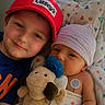 Tanner is registered to the contest to win money with this photo: babies, infants, siblings, faces, portrait, smiling, cuddling, red_cap, striped_hat, pacifier, plush_toy, stuffed_dog, baby_clothing, blanket, crib, bedding, indoor, close_up, family, adorable