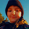 child, portrait, selfie, outdoor, winter, hat, beanie, jacket, puffer_jacket, clothing, face, eyes, smile, sunlight, blue_sky, trees, fashion, star_effects, closeup, person