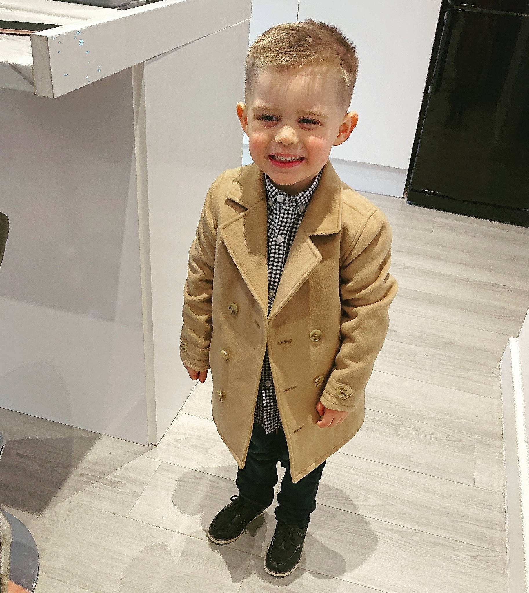 Nico is registered to the contest to win money with this photo: automotive_design, blazer, collar, dress_shirt, eyewear, fashion_design, flooring, formal_wear, joy, neck, person, room, sleeve, smile, standing, street_fashion, suit, tie, toddler, tuxedo