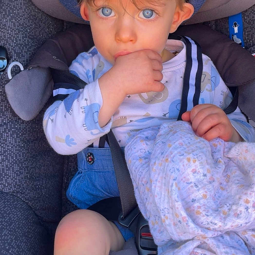 Annet participe au concours pour gagner de l'argent avec cette photo : baby, blanket, blue_eyes, car_seat, casual, child, clothing, cute, expression, face, footwear, hand, hat, indoor, person, portrait, seatbelt, sitting, toddler, young_child