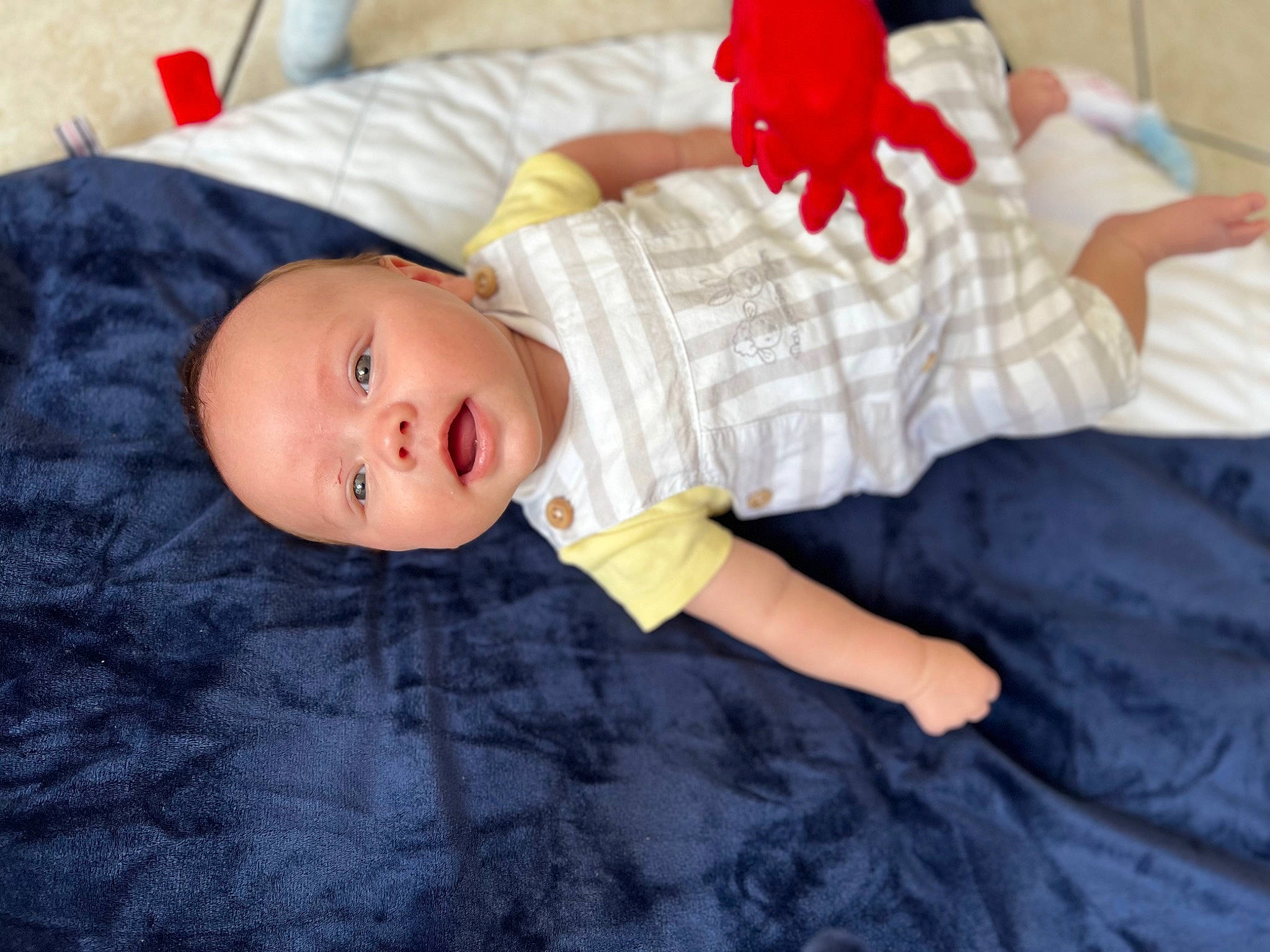 Soren participe au concours pour gagner de l'argent avec cette photo : baby, baby_toddler_clothing, carmine, child, comfort, face, flooring, head, linens, pattern, person, room, sitting, skin, sleeve, toddler
