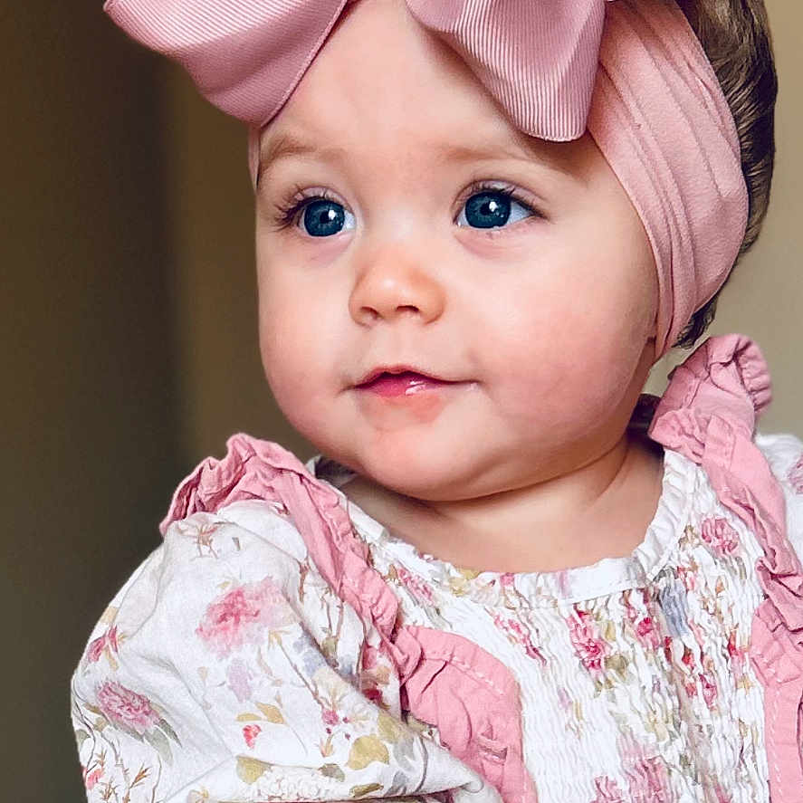 Laramie Kate joined the competition — help win amazing prizes! baby, blue_eyes, bow, cheeks, closeup, cute, eyelashes, fashion, floral_dress, hands, headband, indoor, infant, pink_bow, portrait, rosy_cheeks, ruffles, smiling, soft_lighting, toddler