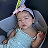 baby, child, infant, car_seat, headband, pink_bow, dress, clothing, face, skin, hair, seat, child_seat, relaxed, cute, young_child, indoors, person, portrait, sleepy