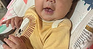 Adalynn is registered to the contest to win money with this photo: baby, infant, child, blue_eyes, yellow_shirt, lion_graphic, baby_seat, bright_starts, hands, curly_hair, cute, indoors, colorful, soft_toys, closeup, portrait, happy, chubby_cheeks, exploring, clothing