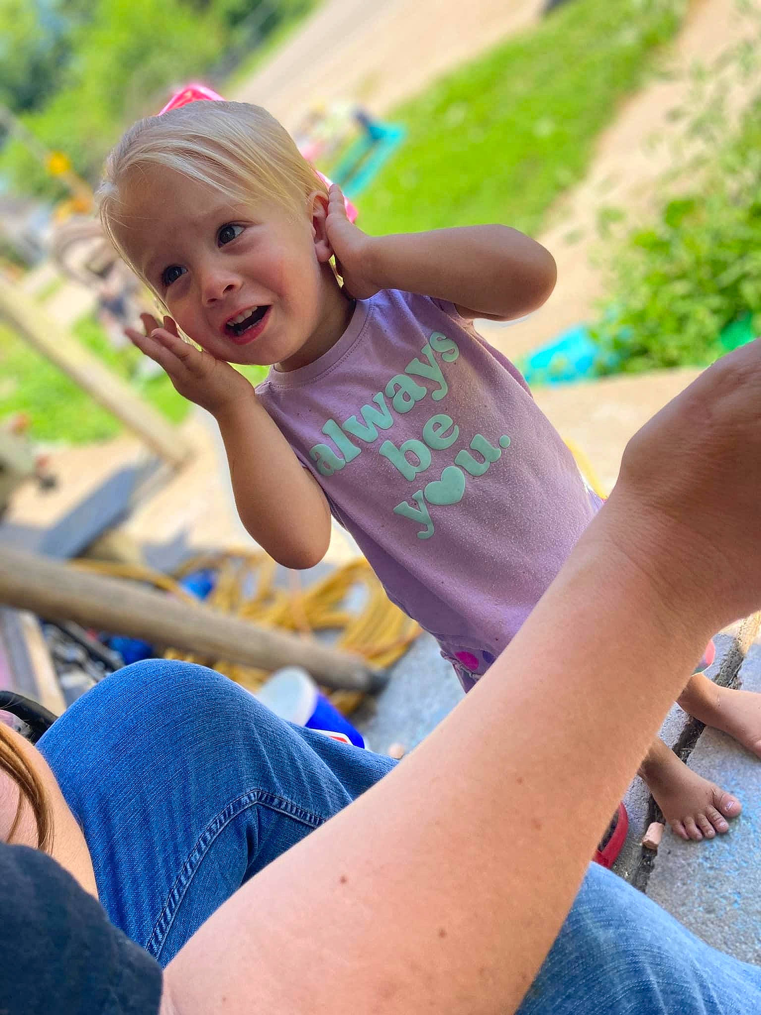 Paisley is registered to the contest to win money with this photo: child, elbow, face, grass, hair, hand, happy, head, human_body, jeans, knee, leisure, person, plant, recreation, summer, thigh, toddler, tree, trunk