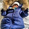 baby, infant, sleeping, winter, snowsuit, blue_coat, hood, fur_trim, pacifier, white_hat, bundled_up, baby_clothing, lying_down, blanket, indoor, portrait, face, closed_eyes, cozy, photography