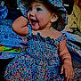 baby, child, smiling, happy, floral_dress, hat, indoors, sitting, cute, joyful, portrait, infant, colorful, clothing, person, playful, young_child, cheerful, face, cute_outfit