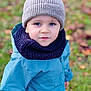 Milo a rejoint le concours — aidez-le/la à gagner de superbes lots ! toddler, child, blue_jacket, scarf, knit_hat, outdoor, autumn, grass, leaves, portrait, face, person, winter_clothing, cute, young_child, smiling, seasonal, nature, warm_clothes, curious