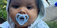 Jaden is registered to the contest to win money with this photo: baby, pacifier, hooded_towel, dinosaur_print, close_up, outdoor, lake, water, child, person, nature, trees, sky, summer, people, shore, grass, cute, infant, daytime