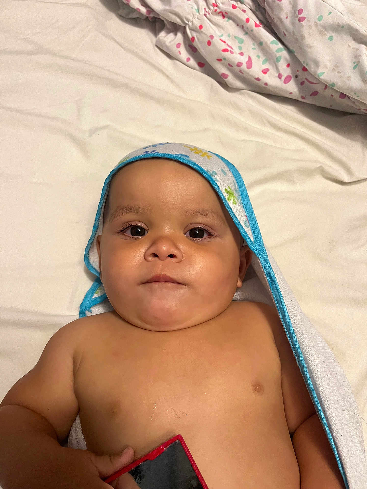 Jaden is registered to the contest to win money with this photo: baby, child, towel, bed, blanket, skin, face, eyes, hand, indoor, infant, cute, portrait, expression, young, person, clothing, resting, laying, holding