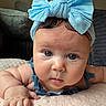 baby, blue_bow, headband, blue_eyes, infant, cute, close_up, portrait, soft_blanket, toddler, skin, hand, face, expression, indoors, cushion, clothing, person, baby_girl, curious