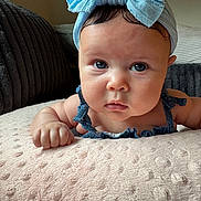 Zalayah is registered to the contest to win money with this photo: baby, blue_bow, headband, infant, face, eyes, blanket, couch, indoor, portrait, cute, child, skin, furniture, soft_texture, clothing, ruffles, expression, closeup, resting