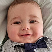 Nolan participe au concours pour gagner de l'argent avec cette photo : baby, infant, smiling, bow_tie, shirt, close_up, face, cheeks, eyes, eyelashes, pillow, bed, clothing, portrait, adorable, innocence, skin, mouth, nose, hair