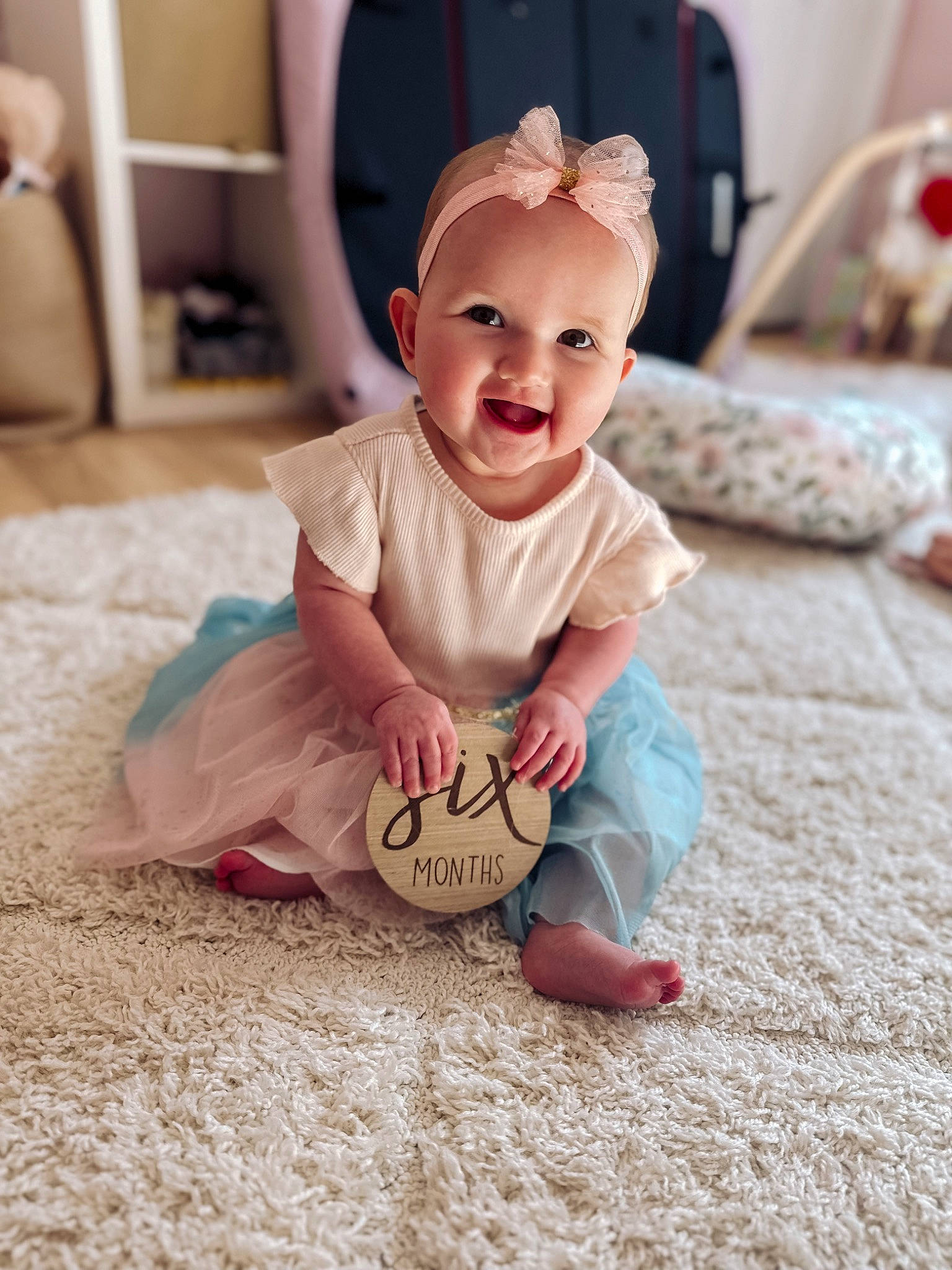 Camila joined the competition — help win amazing prizes! baby, baby_toddler_clothing, cheek, child, chin, comfort, floor, flooring, foot, fun, happy, head, joy, person, pink, sitting, skin, sleeve, smile, t_shirt