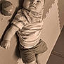 Naël a rejoint le concours — aidez-le/la à gagner de superbes lots ! baby, child, infant, toy, ball, striped_shirt, shorts, puzzle_mat, floor, curious, lying_down, indoors, soft_texture, cheeks, cute, casual_clothing, sepia_tone, playtime, young, portrait