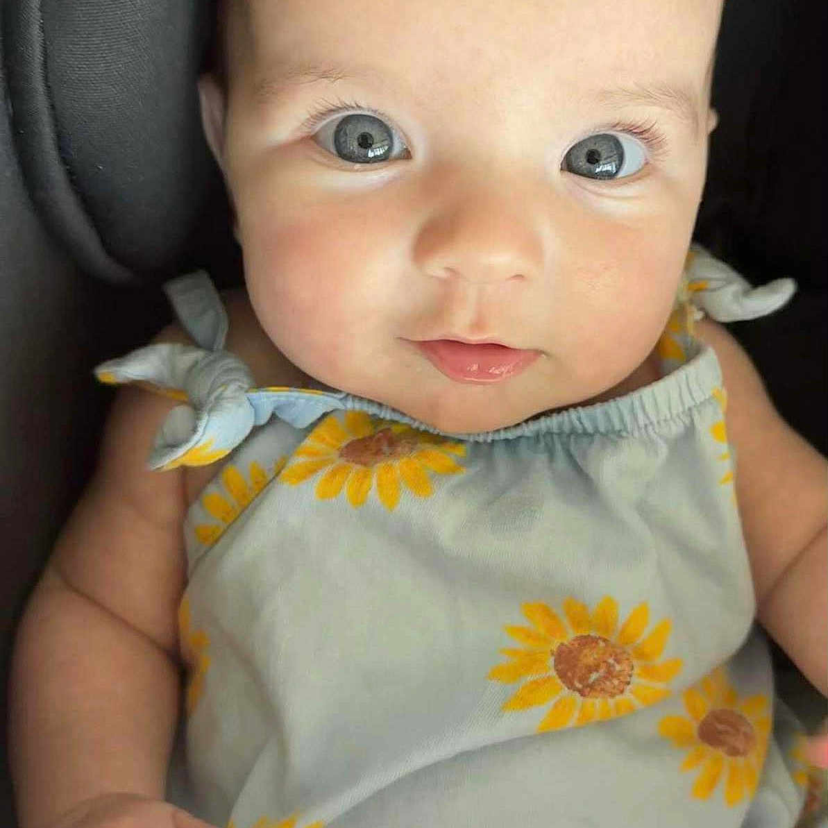 Sophie joined the competition — help win amazing prizes! adorable, apparel, baby, child, closeup, clothing, cute, expression, eyes, face, hand, infant, natural_light, person, portrait, sitting, skin, soft_lighting, sunflower_pattern, young