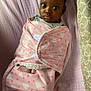 baby, child, blanket, pink, heart_pattern, bed, sheet, cushion, lying_down, wrapped, face, wide_eyes, indoor, soft_texture, cozy, infant, person, portrait, cute, sleeping_area