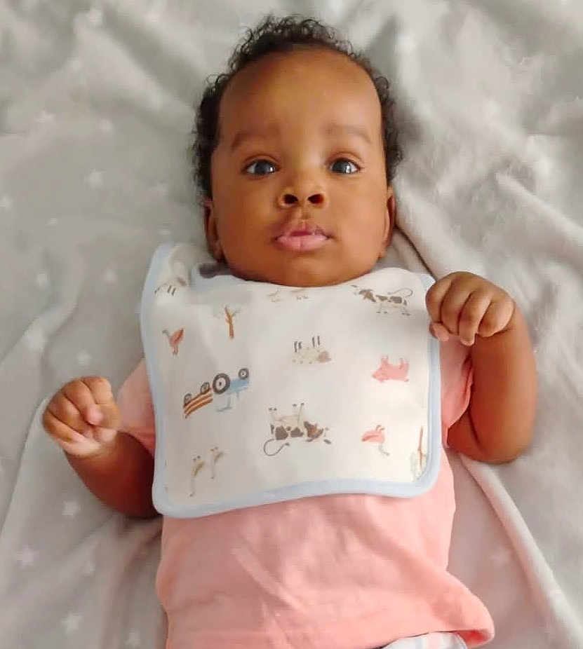 Elliott joined the competition — help win amazing prizes! baby, infant, child, face, eyes, bib, pink_shirt, blanket, animal_prints, cute, lying_down, soft_texture, indoors, portrait, young_child, hands, curly_hair, calm_expression, closeup, sleepwear