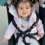 éline a rejoint le concours — aidez-le/la à gagner de superbes lots ! child, toddler, stroller, pink_jacket, white_tights, smiling, hair_tied, outdoor, baby, cute, seatbelt, person, face, clothing, baby_stroller, small_child, casual, happy, young, portrait