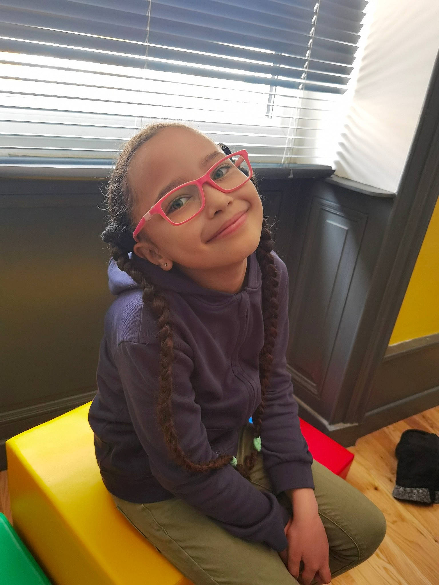 Cataleya a rejoint le concours — aidez-le/la à gagner de superbes lots ! backpack, child, comfort, eyewear, facial_expression, floor, flooring, fun, glasses, happy, human_leg, joy, lap, leisure, luggage_and_bags, person, sitting, smile, standing, thigh