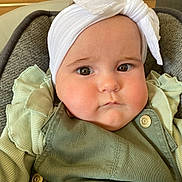 Luna participe au concours pour gagner de l'argent avec cette photo : baby, child, face, headband, bow, green_clothing, ruffles, cushioned_seat, indoors, portrait, cute, chubby_cheeks, serious_expression, infant, button, fabric, person, closeup, headwear, young_child