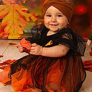 Fybie a rejoint le concours — aidez-le/la à gagner de superbes lots ! child, baby, toddler, orange_dress, headband, autumn, leaves, smile, portrait, studio, sitting, wooden_floor, holding_leaf, eyes, cheeks, cute, festive, black_tulle, background_bokeh, seasonal