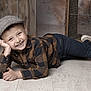 Wesley a rejoint le concours — aidez-le/la à gagner de superbes lots ! child, boy, smiling, lying_down, pose, flat_cap, hat, checkered_shirt, flannel_shirt, jeans, earring, wooden_crate, rustic, indoor, portrait, happy, flooring, shoes, hands, studio