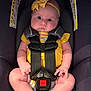 baby, infant, car_seat, yellow_bow, yellow_clothing, seatbelt, chubby_cheeks, wide_eyes, child, sitting, safety_harness, cute, portrait, indoor, infant_girl, headband, pink_skin, expression, closeup, child_safety