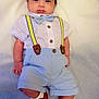 baby, infant, bow_tie, suspenders, red_shoes, socks, shorts, shirt, buttons, lying_down, portrait, cute, eyes_open, hands, feet, blanket, soft_lighting, white_background, fashion, outfit