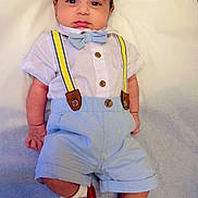 Avik is registered to the contest to win money with this photo: baby, infant, bow_tie, suspenders, red_shoes, socks, shorts, shirt, buttons, lying_down, portrait, cute, eyes_open, hands, feet, blanket, soft_lighting, white_background, fashion, outfit