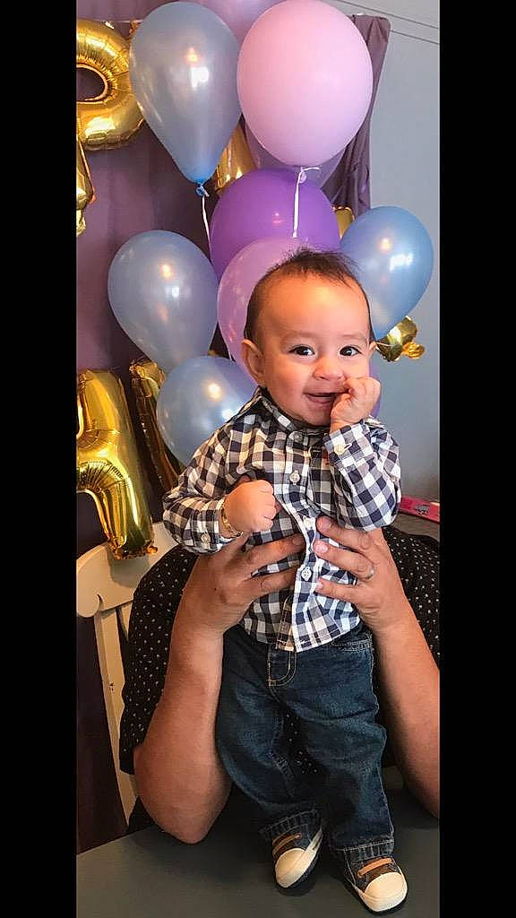 Juanito is registered to the contest to win money with this photo: balloon, child, fun, girl, happiness, party_supply, person, pink, product, purple, sitting, smile, toddler, toy