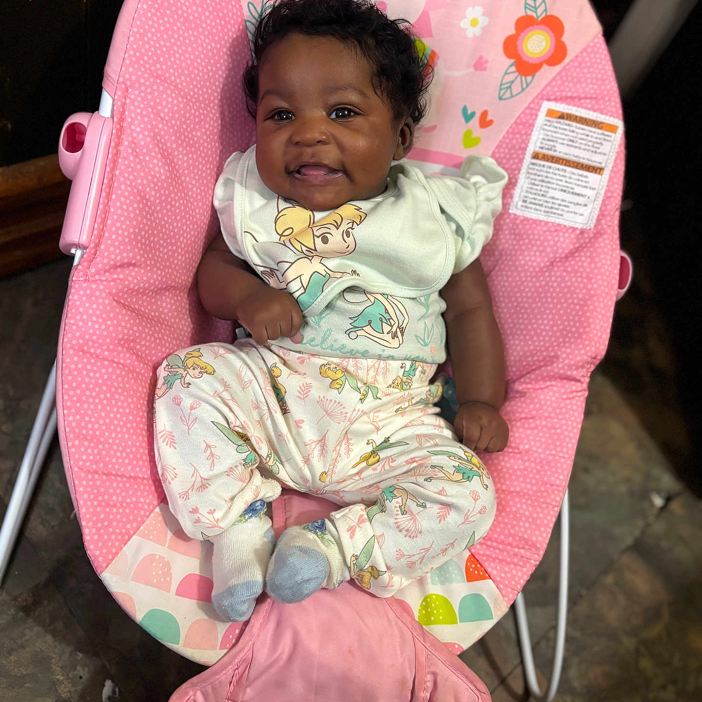 Khilani joined the competition — help win amazing prizes! baby, baby_seat, child, colorful, curly_hair, cute, cute_baby, floor, happy, indoor, infant, joyful, patterned_clothing, pink_baby_chair, portrait, seated, small_child, smiling, sock, tinkerbell_outfit