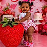 Khilani is registered to the contest to win money with this photo: baby_clothes, balloons, barefoot, cake, celebration, child, cute, decorations, fruit, hair_bows, happy, indoor, party, pigtails, pink, portrait, prop, smiling, strawberry, toddler