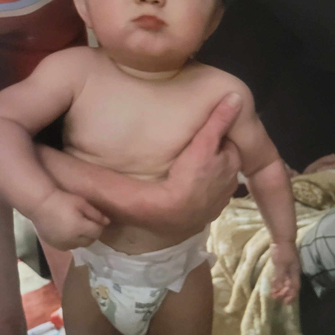 Lucas joined the competition — help win amazing prizes! arm, baby, blanket, casual, child, closeup, cute, diaper, expression, floor, furniture, hand, holding, human, indoor, infant, person, pout, room, skin