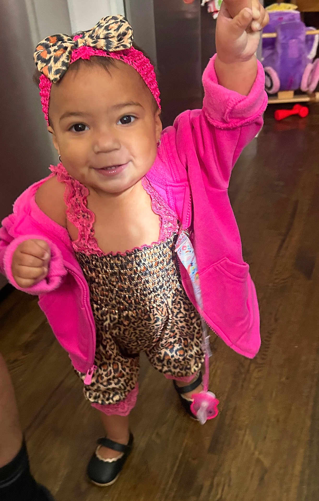 Kassandra joined the competition — help win amazing prizes! toddler, child, indoor, pink_jacket, leopard_print, headband, pacifier, smiling, happy, floor, shoes, person, clothing, cute, baby, small_child, standing, hand_raised, wooden_floor, footwear