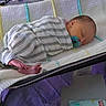 Naomi is registered to the contest to win money with this photo: baby, newborn, sleeping, pacifier, swaddle, blanket, striped_clothing, infant, bed, cozy, rest, peaceful, soft_lighting, indoor, purple_bedspread, baby_wipes, nursery, cute, child, person