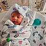 newborn, baby, hospital, incubator, medical_equipment, blanket, footprints, pacifier, striped_hat, bow, wrapped, infant, bed, healthcare, cute, person, patient, nursery, small, lying_down