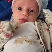 Berkeley is registered to the contest to win money with this photo: baby, infant, pink_bow, hat, onesie, bear_pattern, quilt, blanket, floral, clothing, face, eyes, cute, newborn, portrait, lying_down, headwear, baby_clothes, closeup, child