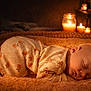 baby, sleeping, pajamas, blanket, face, infant, cozy, candles, warm_light, bedtime, peaceful, cute, soft_texture, indoors, rest, newborn, comfort, portrait, relaxation, child