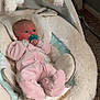 baby, infant, pacifier, pink_onesie, plush_toys, baby_rocker, carpet, indoor, cute, child, soft_toys, baby_clothing, newborn, resting, comfort, young_child, floor, baby_bedding, stuffed_animals, relaxing