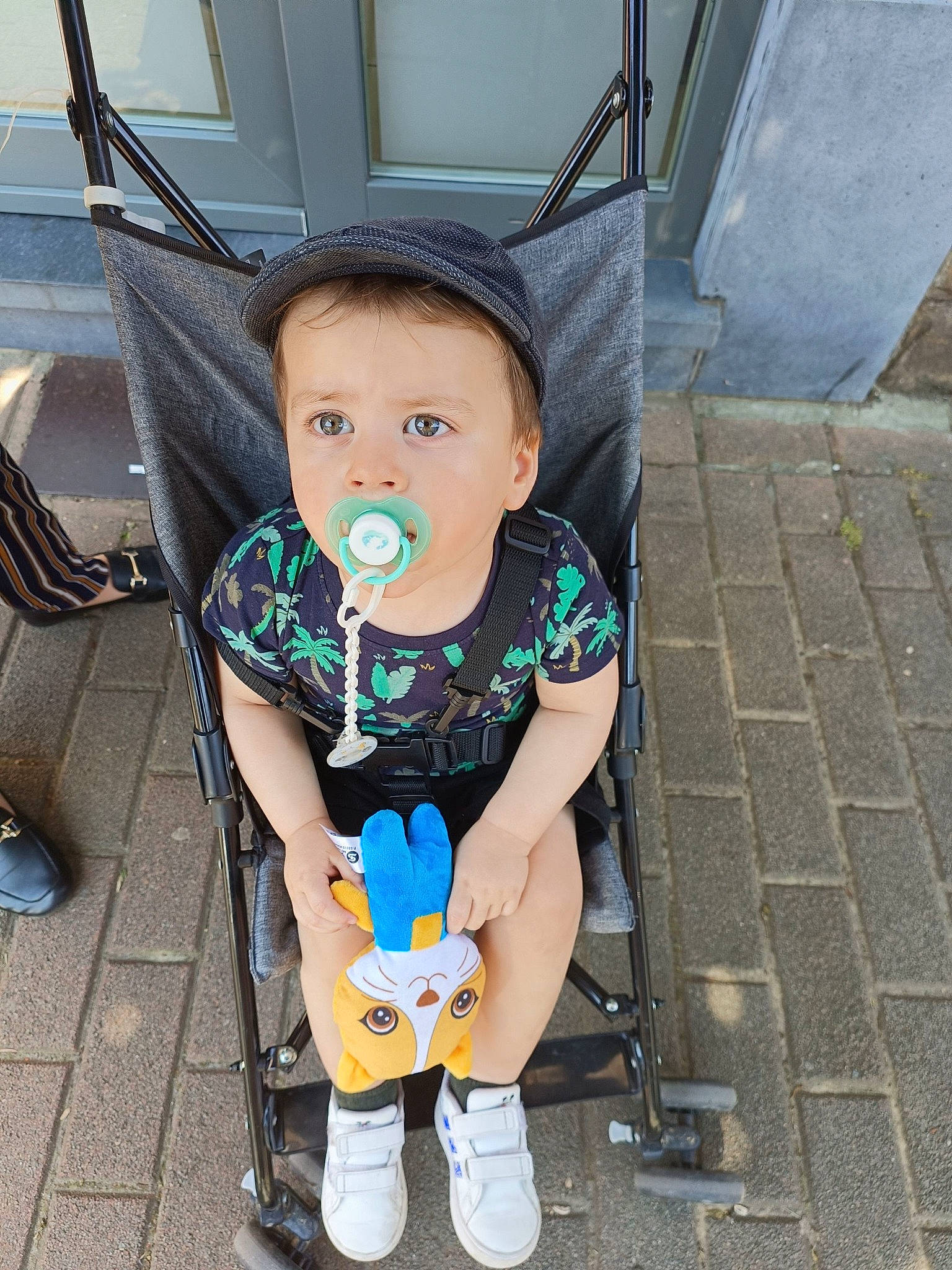 Evan a rejoint le concours — aidez-le/la à gagner de superbes lots ! auto_part, baby, baby_carriage, baby_products, baby_toddler_clothing, chair, child, electric_blue, flooring, fun, happy, human_leg, leg, person, sandal, shoe, sidewalk, sitting, sneakers, t_shirt