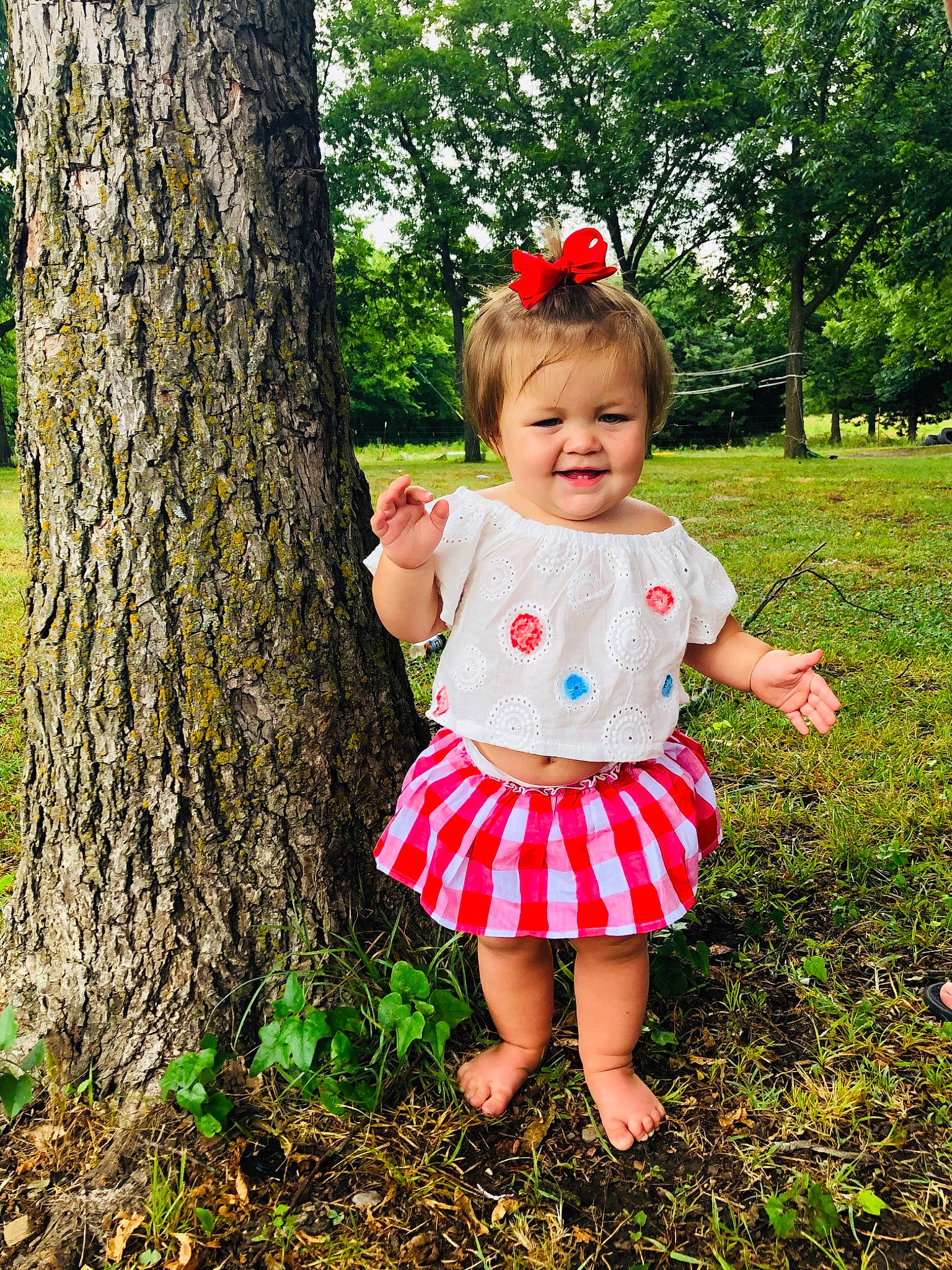 Alianna is registered to the contest to win money with this photo: baby_toddler_clothing, child, child_model, design, dress, grass, green, joy, pattern, people_in_nature, person, photo_shoot, photography, plant, red, shortstraw_pine, spring, toddler, tree, wildflower