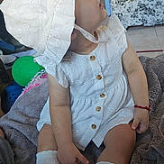 Daylene joined the competition — help win amazing prizes! arm, blanket, bonnet, bracelet, buttoned_dress, child, curious, face, floor, furniture, household, indoor, knee_high_socks, patterned_drawers, room, sitting, tile_floor, toddler, toy, white_dress