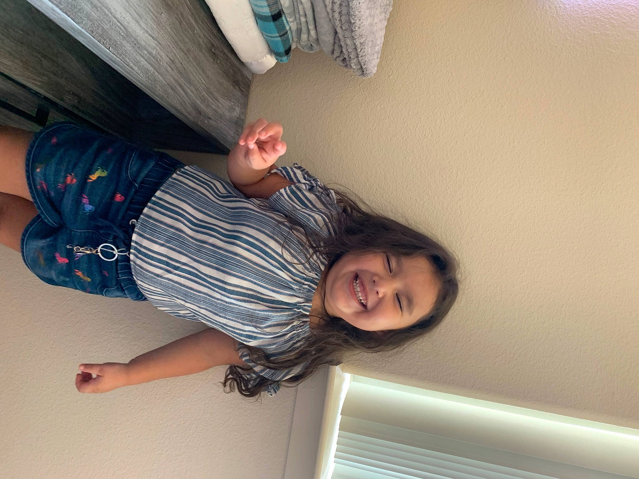 Camila is registered to the contest to win money with this photo: arm, black_hair, comfort, elbow, fun, gesture, happy, human_leg, joint, joy, knee, long_hair, person, room, sleeve, smile, thigh, thumb, tints_and_shades, trunk