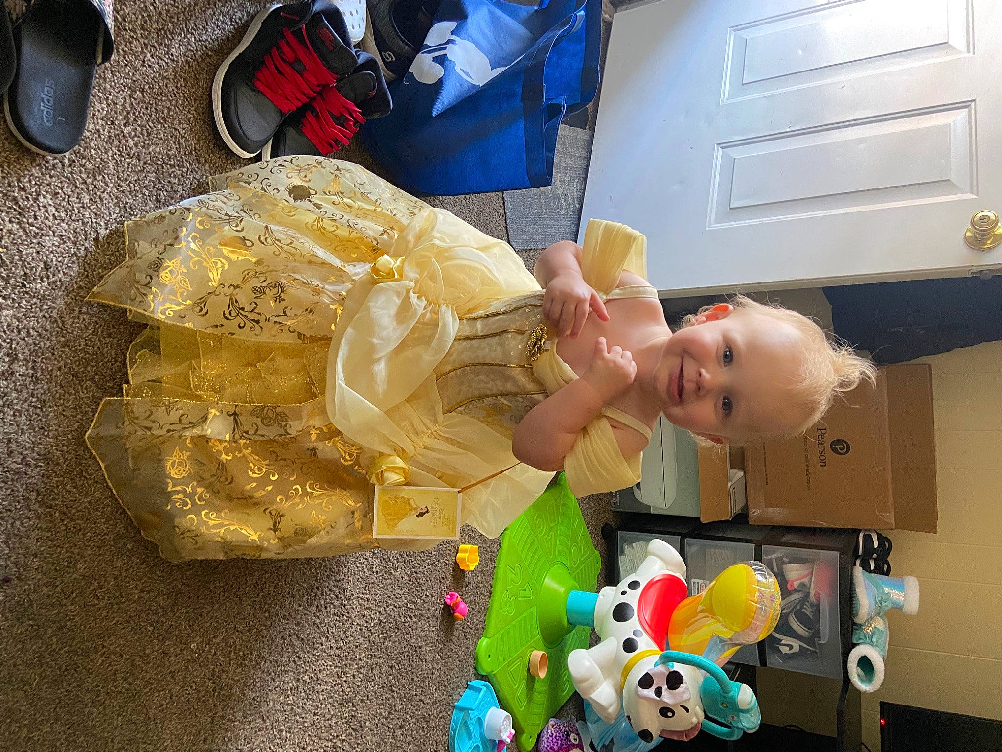 Emmie is registered to the contest to win money with this photo: baby, baby_products, baby_toddler_clothing, baby_toys, bag, cabinetry, child, fictional_character, fun, hat, joy, luggage_and_bags, person, plastic, play, refrigerator, room, smile, toddler, toy
