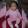 Hazel is registered to the contest to win money with this photo: toddler, child, pink_clothing, hoodie, socks, bow, indoor, sitting, portrait, face, cute, baby, young_child, fashion, casual, red_background, person, apparel, expression, cozy