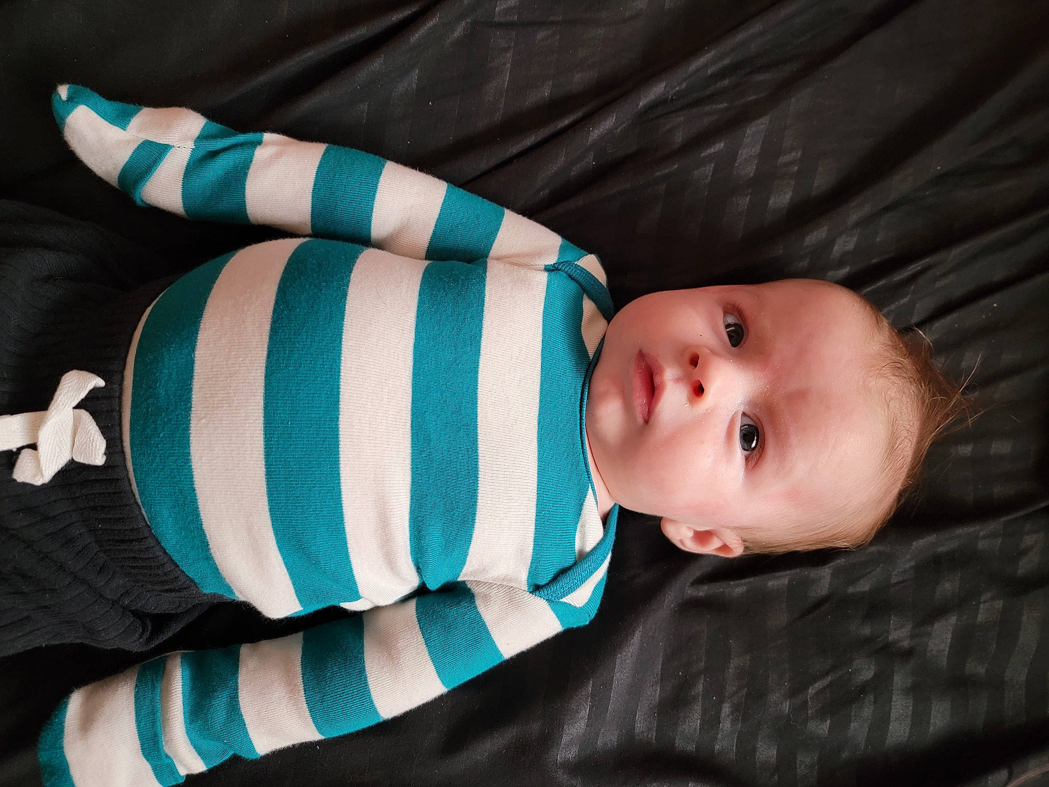 Koda is registered to the contest to win money with this photo: baby, baby_products, baby_toddler_clothing, child, collar, comfort, electric_blue, fashion_accessory, finger, flash_photography, hand, linens, outerwear, pattern, person, sitting, skin, sleeve, textile, toddler