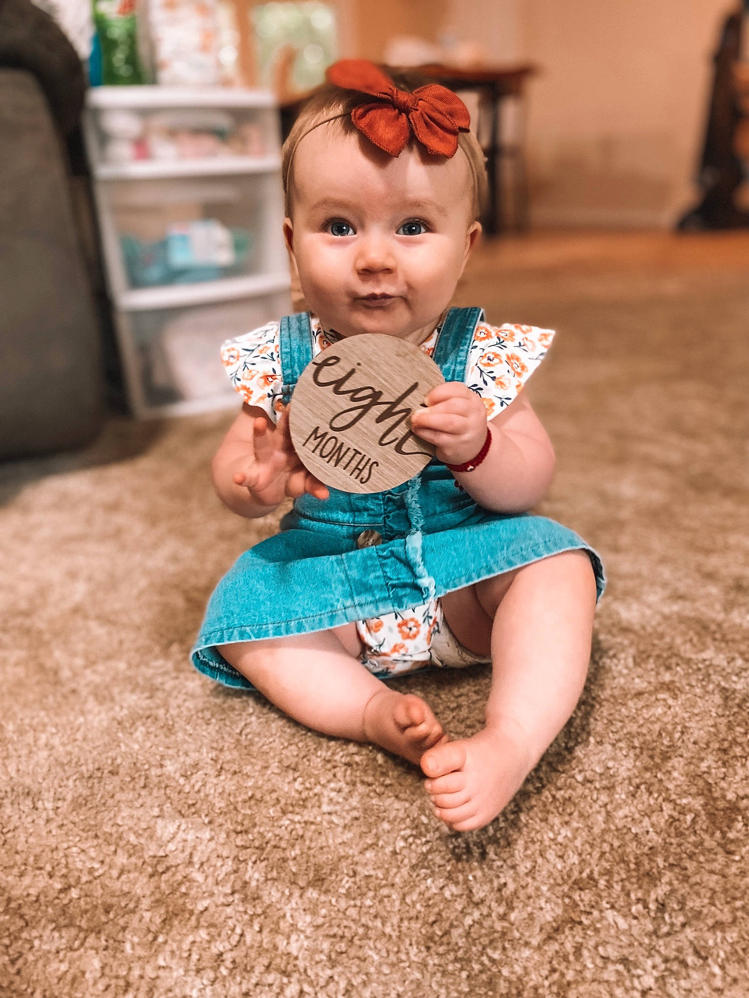 Drew is registered to the contest to win money with this photo: baby, baby_toddler_clothing, brown_hair, child, doll, fawn, flooring, foot, fun, happy, head, headgear, human_leg, iris, joint, person, sitting, skin, toddler, toy