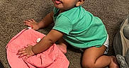 Dream is registered to the contest to win money with this photo: baby, child, crawling, green_shirt, pink_hat, carpet, indoor, furniture, curious, cute, earrings, skin, floor, diaper, person, one_child, toddler, play, home, young